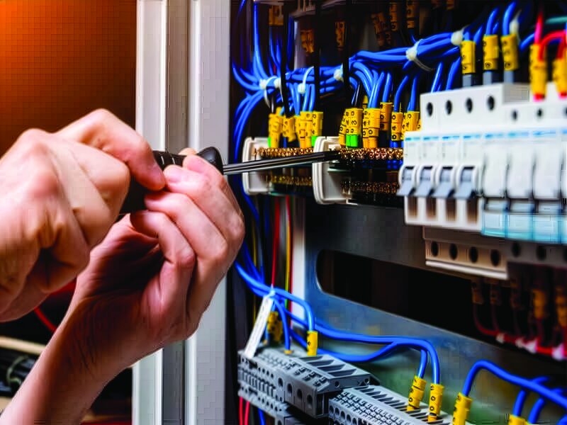 An electrician working inside a distribution board